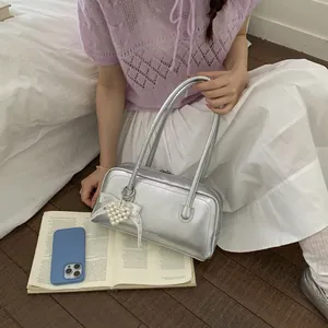 Sac à épaule argenté métallisé avec breloque cœur perlé et nœud sur un mannequin