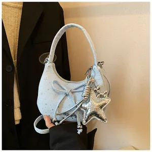 Detail van lichtblauwe halve maan tas met zilveren sterren en metalen ballonhond hanger