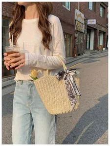 Detail of hand-woven off-white tote bag with floral silk scarf handle and interior lining