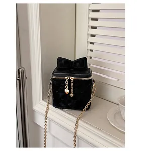 Détail du mini sac matelassé en velours noir avec nœud géant et breloque cœur doré