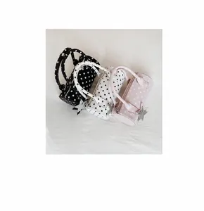 Detailed view of polka dot bowling bags in black white and pink with star charms