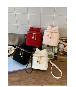 Détail de quatre mini-sacs à matelassage cœur avec nœuds et chaînes dorées