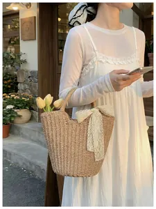 Detail of straw woven bucket bag with elegant white lace bow and a French pastoral style