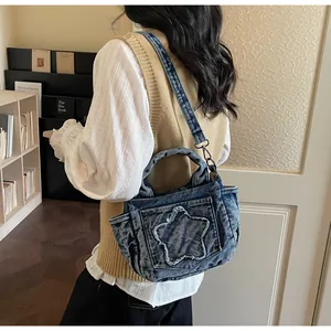 Detailed view of blue denim star tote bag showing texture and adjustable metal buckle