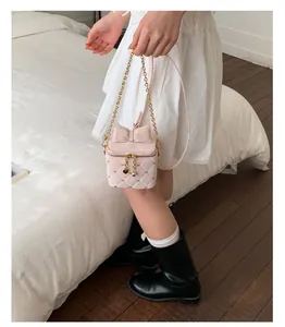 Détail du mini sac bandoulière matelassé rose avec nœud et chaîne dorée chic