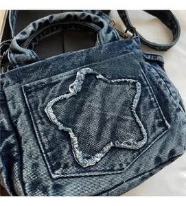 Detailed close-up of blue washed denim handbag with vintage star-shaped patchwork