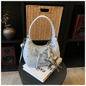 Detail van lichtblauwe denim hobo tas met zilveren sterren en strik trekkoord