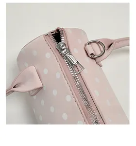 Close-up of a pink polka dot pillow bag showing the smooth silver metal zipper detail