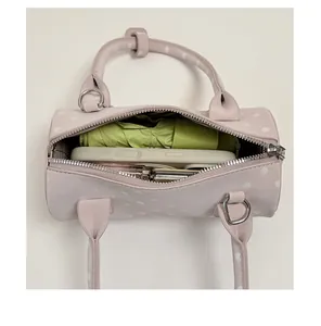 Interior view showing the capacity of a pink polka dot bowling bag with everyday items