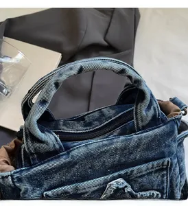 Close-up of durable reinforced handles and secure zipper closure on denim tote bag