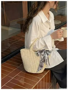 Detail of woven bucket bag with vintage Paris print scarf handle in a French cafe setting