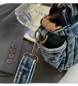 Detailed close-up of blue washed denim bag featuring bronze metal hardware and zipper