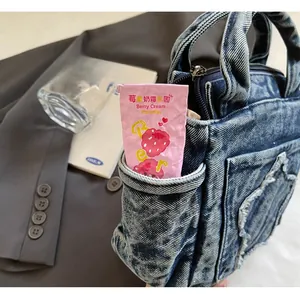 Detail of blue denim tote bag with frayed edges and side pocket for daily casual use