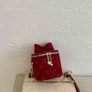 Détails du mini sac bordeaux matelassé avec couture cœur et nœud doré élégant