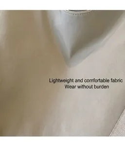 Detailopname van lichtgewicht beige textiel met fijne stiksels en een zachte textuur