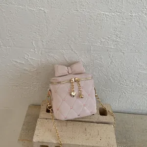 Détail d'un sac bandoulière matelassé rose avec broderie cœur et nœud décoratif chic