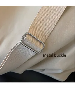 Detailopname van een zilveren metalen gesp op de geweven riem van een beige tote-tas