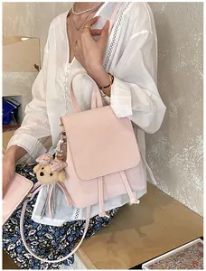 Close-up of pale pink backpack with drawstring detail and cute plush bear charm