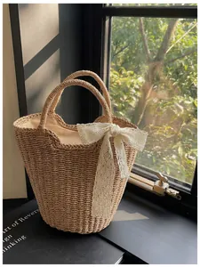 Detailed straw weave texture and white lace bow on the casual summer bucket tote bag