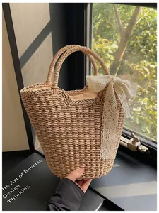 Detail of hand-woven straw tote with white lace bow and sturdy round handles