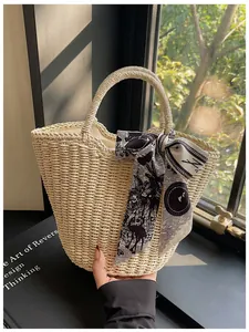 Detail of a beige woven tote bag with a floral print silk scarf on the handle