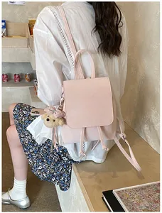Detail of pink faux leather backpack with drawstring closure and cute plush bear charm