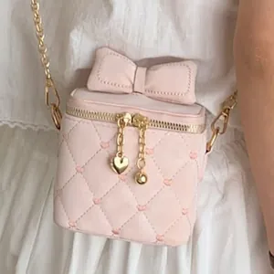 Mini sac à chaîne matelassé rose pâle avec grand nœud et broderie en cœur