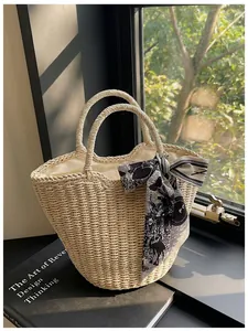 Detail of hand-woven straw tote with wavy edge, decorative scarf and inner lining