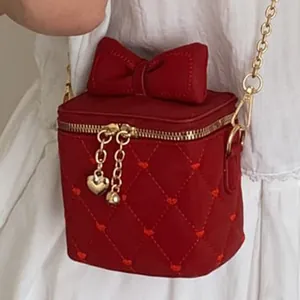 Mini sac rouge matelassé avec grand nœud, broderie cœur et bandoulière dorée