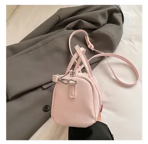 Macro detail of the premium silver hardware and pink lychee leather texture on a Boston bag