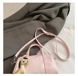 Detail of adjustable shoulder strap on pink Boston bag with a horse charm accent