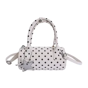 Chic white polka dot barrel handbag with dual handles and star charm accessory