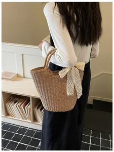 Detail shot of handwoven straw tote bag with a white lace bow in a French style