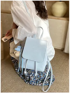 Detail of light blue PU leather backpack with drawstring closure and cute bear pendant