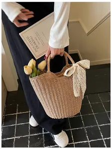 Close-up of woven straw tote bag featuring a delicate white lace bow and floral accent
