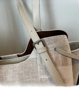 Détail de la bandoulière en cuir avec boucle en argent sur le sac fourre-tout tissé