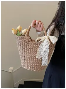 Detail of hand-woven straw tote bag with lace bow and internal tulip floral decoration