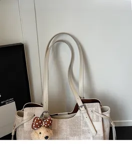 Détail du sac cabas à carreaux avec bandoulière réglable et breloque en peluche