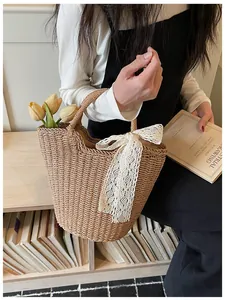 Detail of hand-woven straw tote bag with a white lace bow and vintage French style