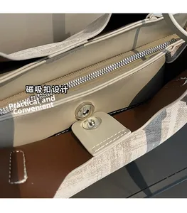 Vue détaillée du bouton pression magnétique et du zip de ce sac fourre-tout chic