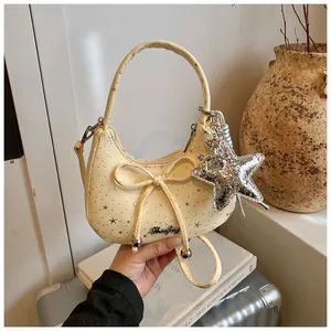 Detail van de lichtgele maantas met sterpatroon, strik en sterrenhangertje