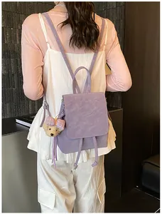 Detail of purple PU leather backpack with drawstring closure and cute plush bear charm