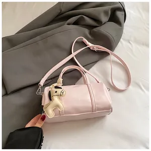 Dettaglio borsa Boston rosa chiaro con cuciture, tracolla e ciondolo a forma di cavallo