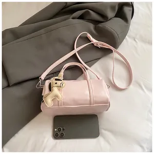 Dettaglio di una borsa Boston rosa con ciondolo a cavallo e smartphone per riferimento taglia