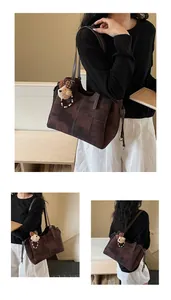 Détail d'un grand sac cabas à motif rétro avec un petit pendentif ours sur modèle