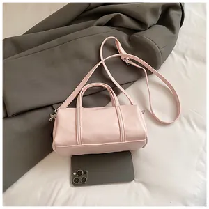 Mini borsa Boston rosa con texture in pelle e smartphone per il confronto delle taglie