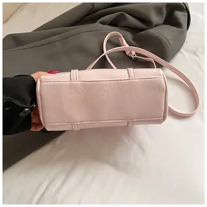 Dettaglio della borsa cilindrica Boston rosa con cuciture fini e tracolla regolabile