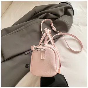 Vista dall'alto di una borsa Boston rosa chiaro con grana litchi e dettagli argento
