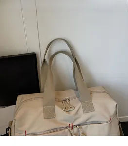 Dettaglio borsa da viaggio in tela con doppi manici resistenti e cuciture rosse