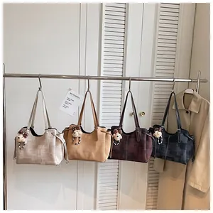 Détail de sacs fourre-tout en quatre coloris avec pendentifs ours et cordons de serrage